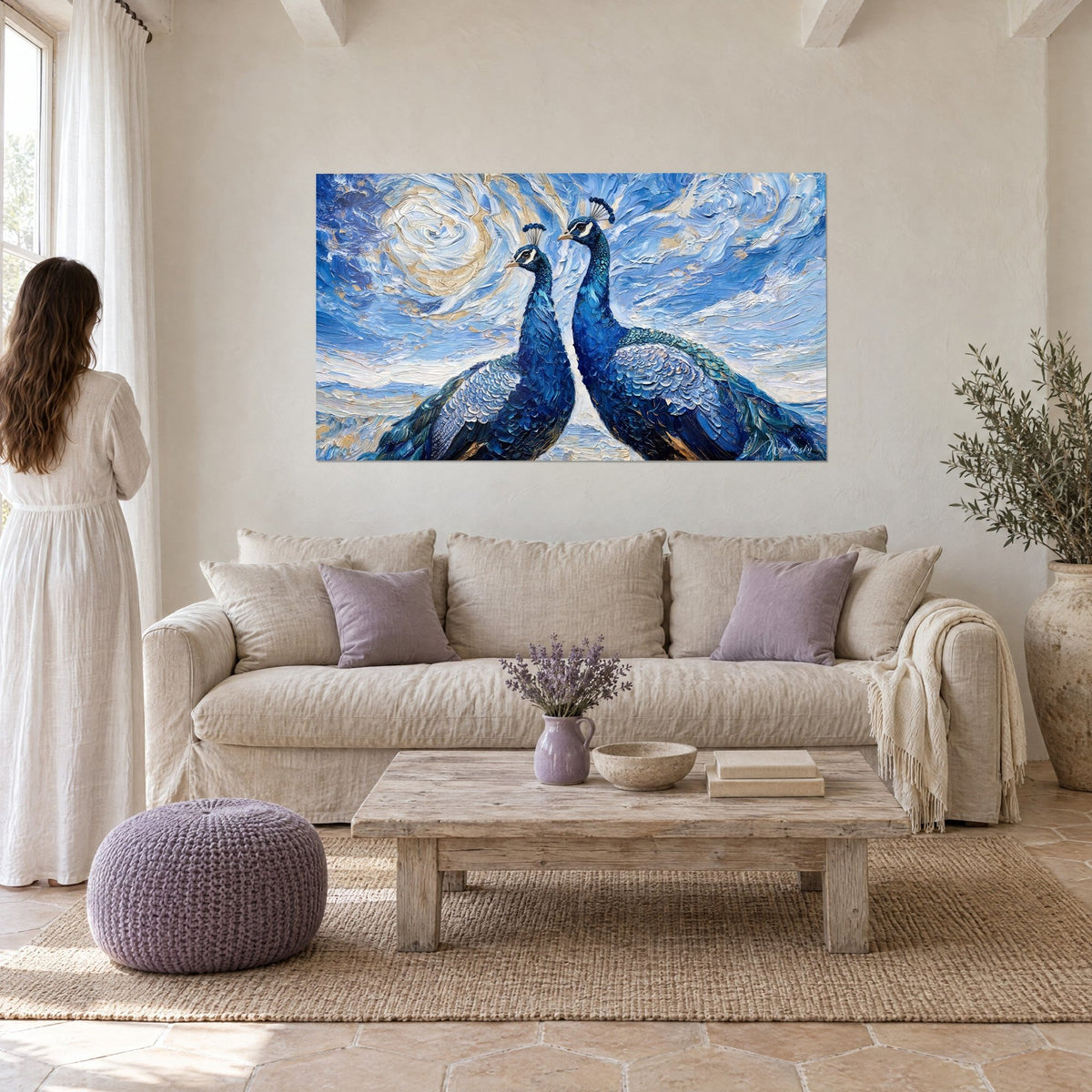 Wall art two peacocks with cobalt blue plumage, textured oil painting on a swirling cream and gold sky, above a sofa in a bright living room