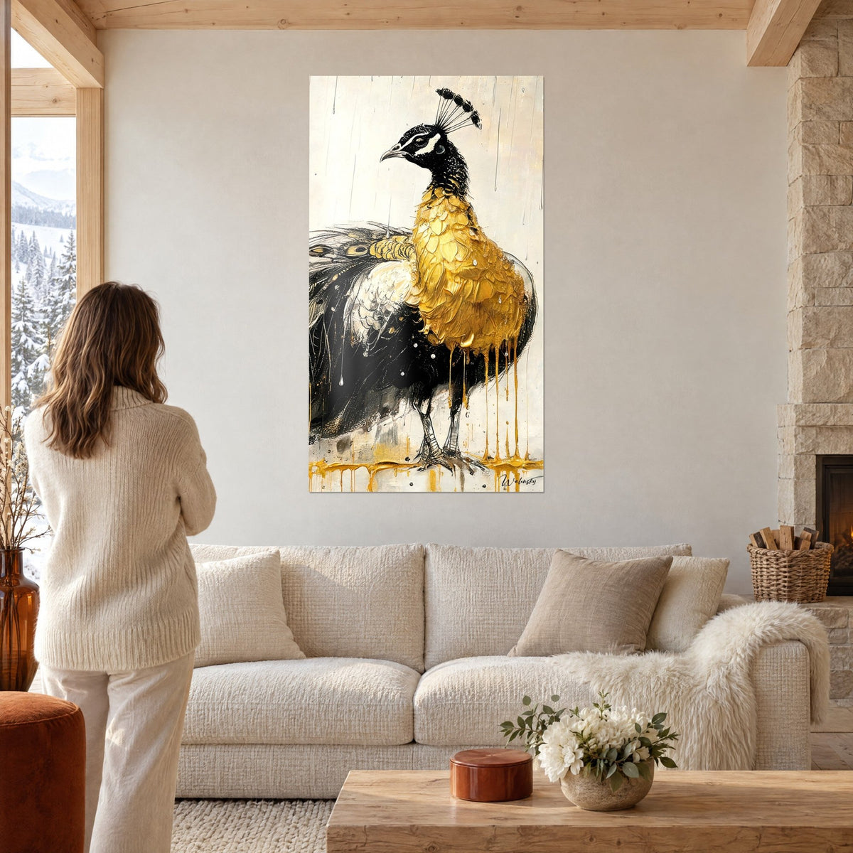 Cuadro pavo real con pecho dorado grueso y plumaje negro, goteos dorados, mujer de espaldas, encima de un sofá en un salón luminoso