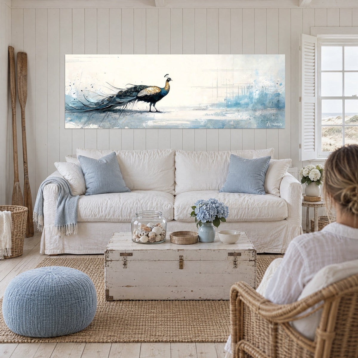 Gemälde Pfau in Nachtblau und Gold, ausgefranster Schweif, azurblaue Spritzer, über einem Sofa in einem hellen Wohnzimmer