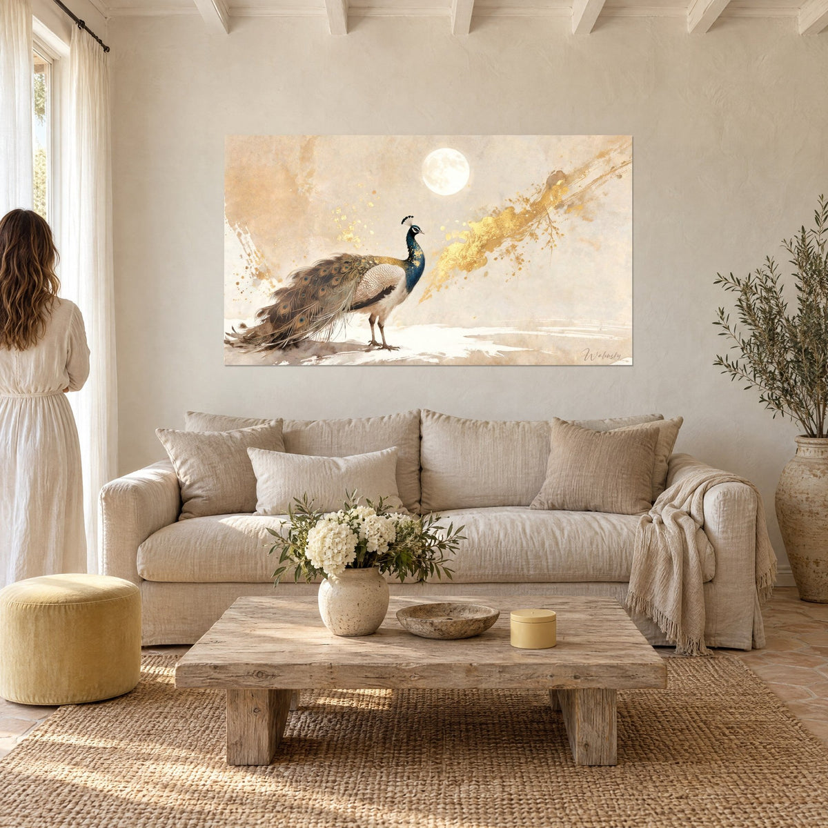Tableau paon bleu et brun, queue traînante ornée d'ocelles, lune pâle et éclaboussures d'or, au-dessus d'un canapé dans un salon lumineux