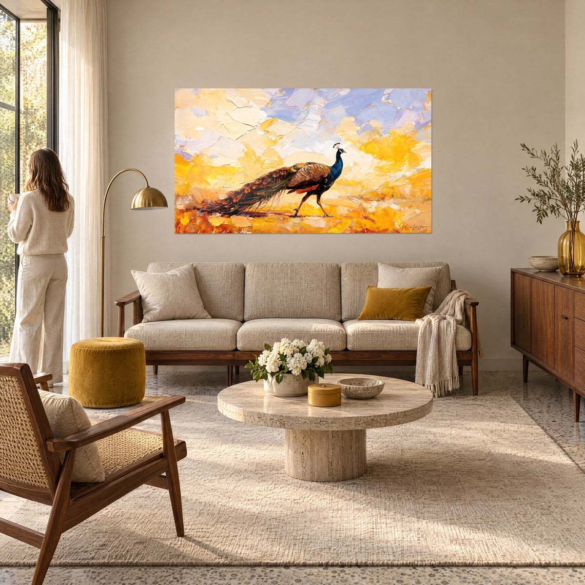 Gemälde eines schreitenden blauen Pfaus, kupferfarbene Schleppe vor gelbem und lila Himmel, Frau von hinten, über einem Sofa in einem hellen Wohnzimmer