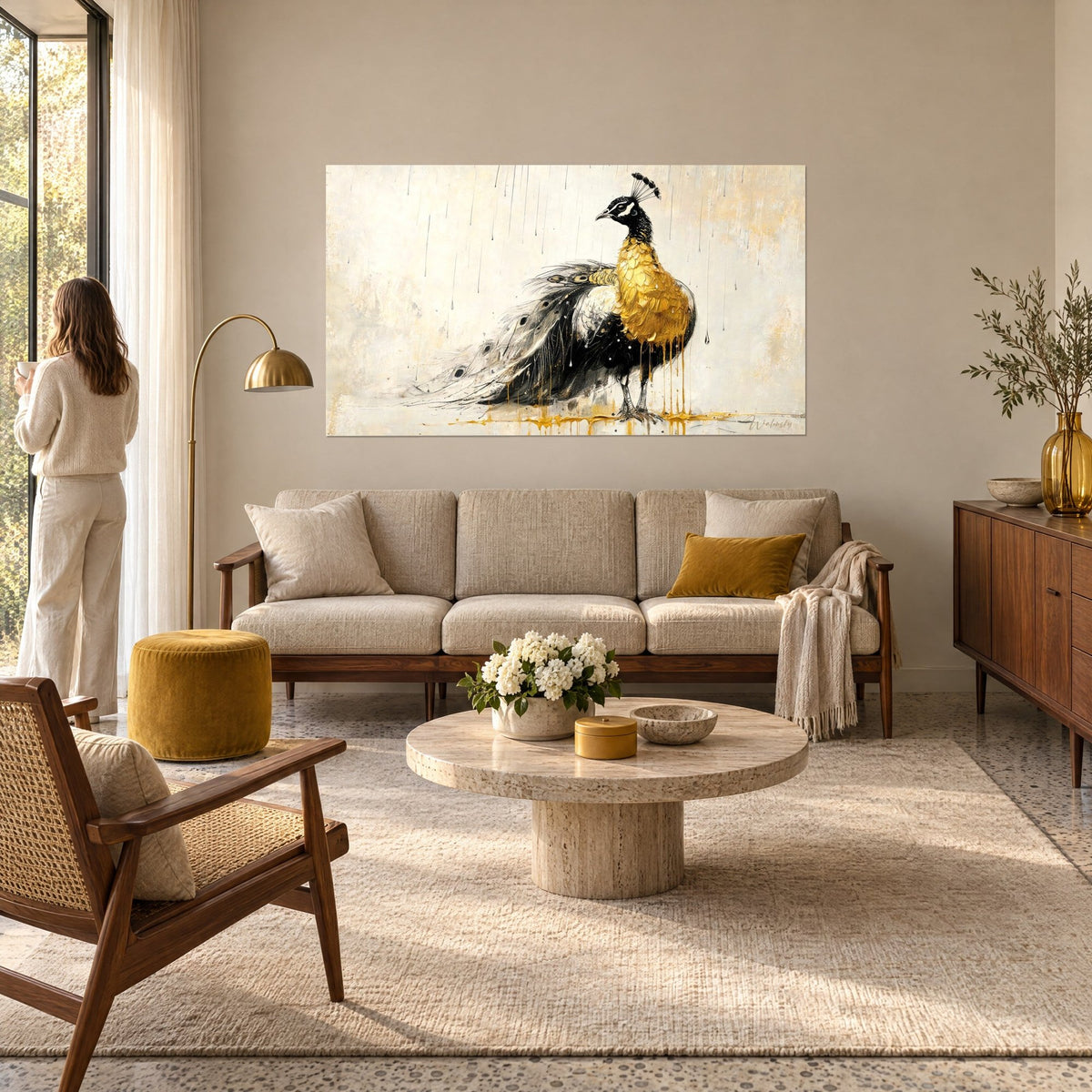 Wall art peacock with thick golden chest and long black-and-white train, a woman seen from behind gazes at it above a sofa in a bright living room