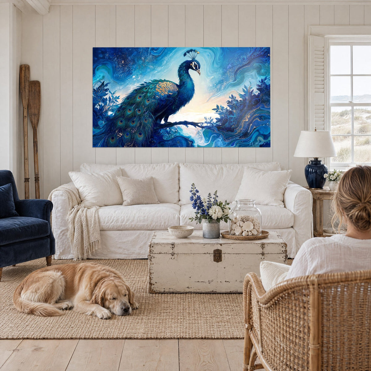 Tableau paon aux plumes ocellées vert émeraude, croupe dorée sur ciel bleu cobalt, au-dessus d'un canapé dans un salon lumineux