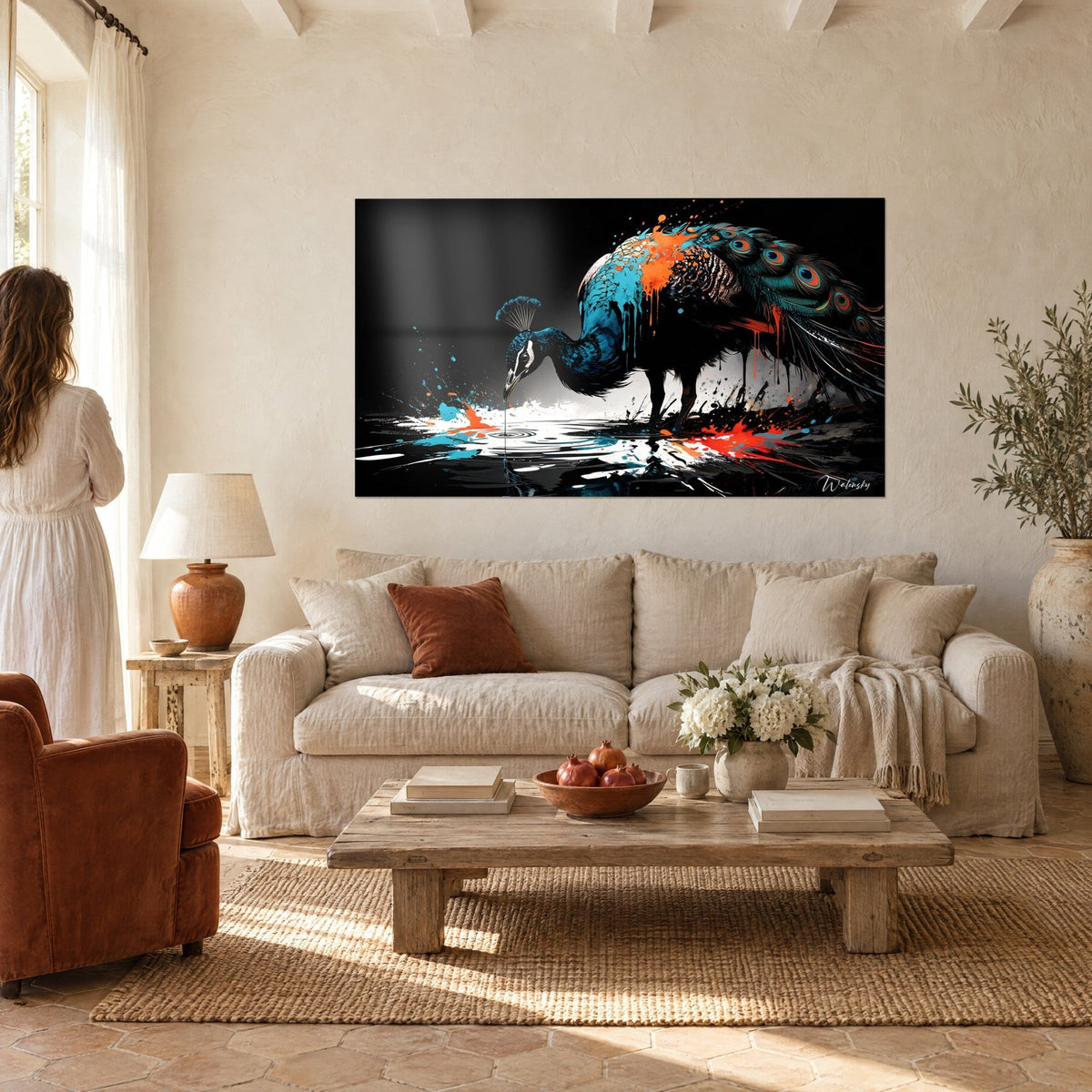 Tableau paon penché sur une eau noire, plumage bleu pétrole et éclaboussures orange, femme de dos, au-dessus d'un canapé dans un salon lumineux