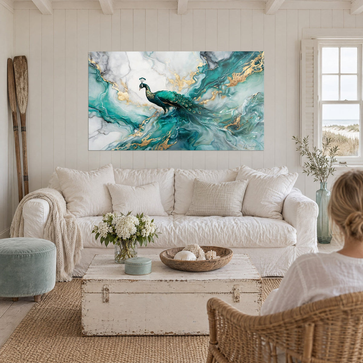 Tableau paon émeraude, queue ocellée, perché sur un marbre blanc veiné d'or, spectatrice de dos, au-dessus d'un canapé dans un salon lumineux