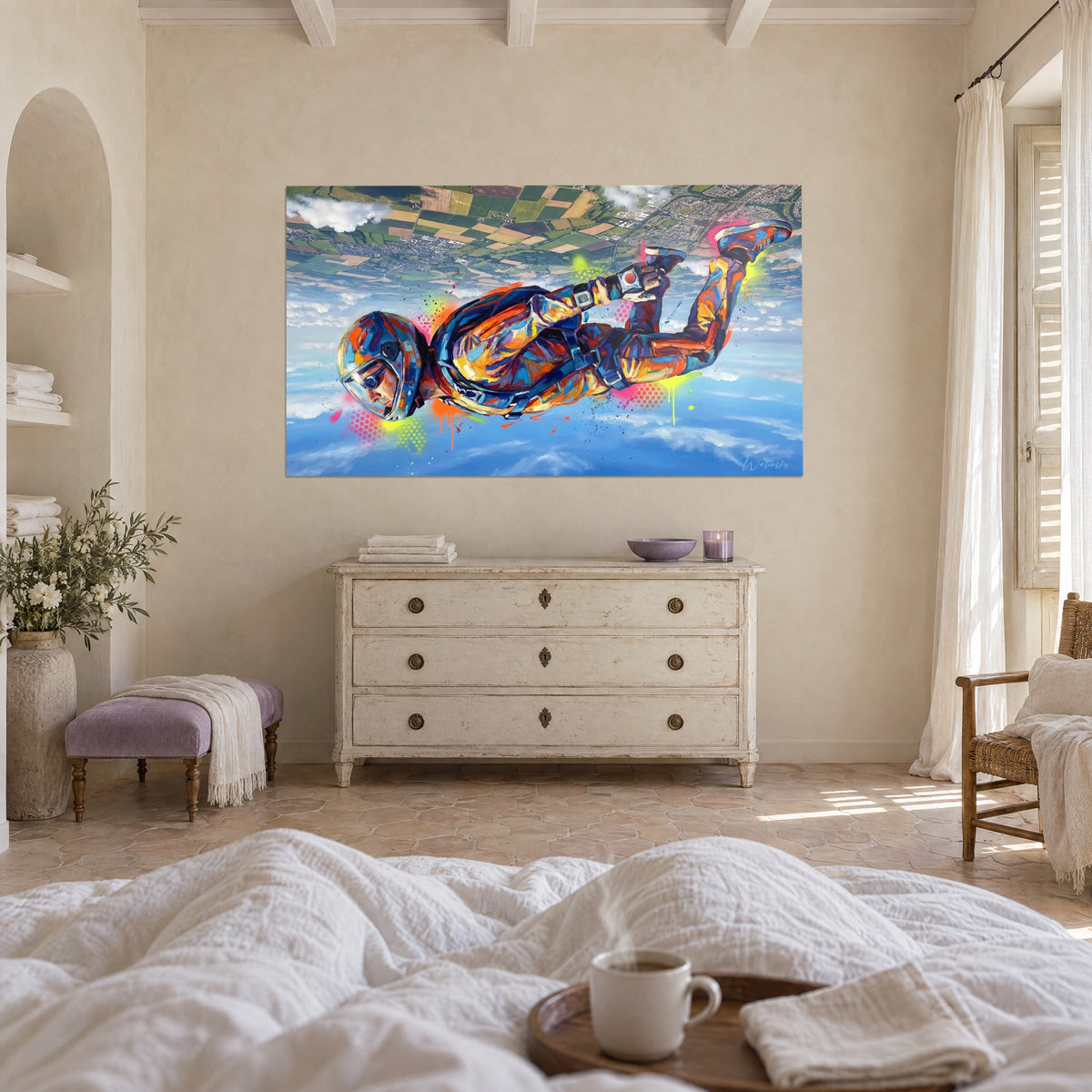 Gemälde eines Springers im horizontalen Flug, blauer Helm und gelb-orangefarbene Jacken, weiße Wolken, über einem Bett in einem hellen Schlafzimmer
