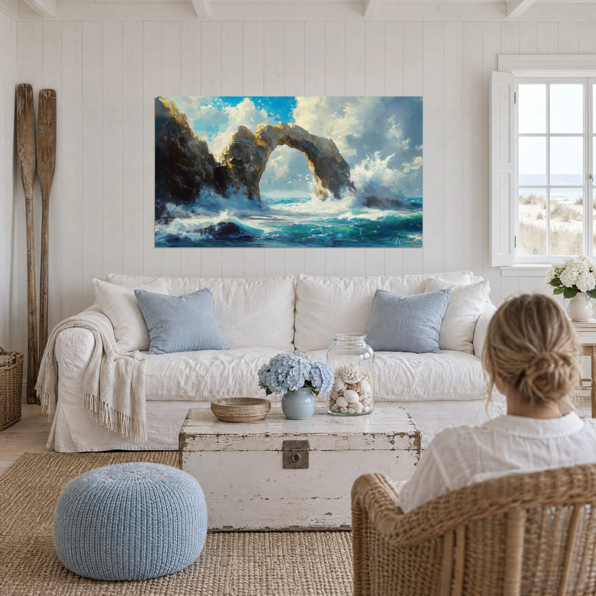 Tableau arche rocheuse sculptée par les vagues, falaise ocre et mer turquoise, au-dessus d'un canapé dans un salon lumineux