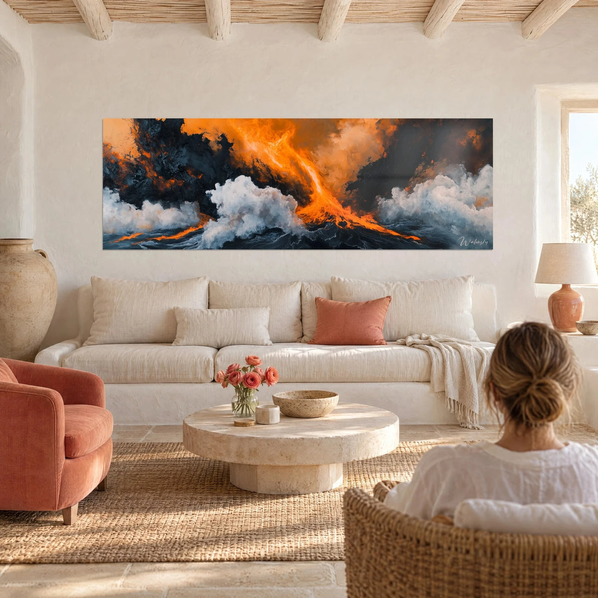 Quadro di lava arancione che zampilla tra schiuma bianca e roccia nera, donna di spalle sopra un divano in un soggiorno luminoso
