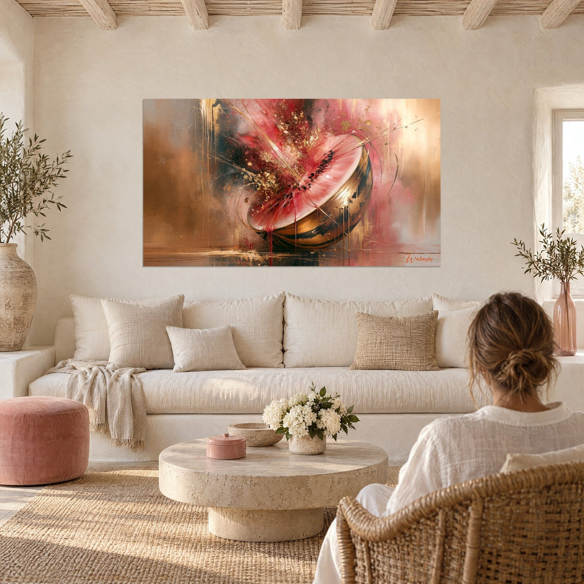 Wall art of a halved pink and gold watermelon bursting into gold shards, above a sofa in a bright living room