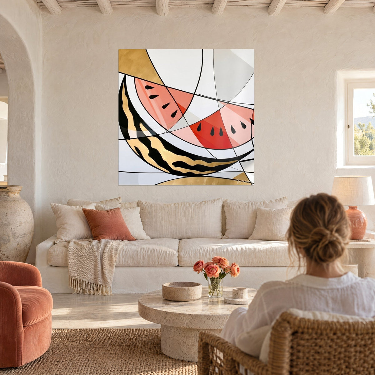 Tableau pastèque stylisée aux quartiers corail et aux graines noires, filets noirs et feuille d'or, au-dessus d'un canapé dans un salon lumineux