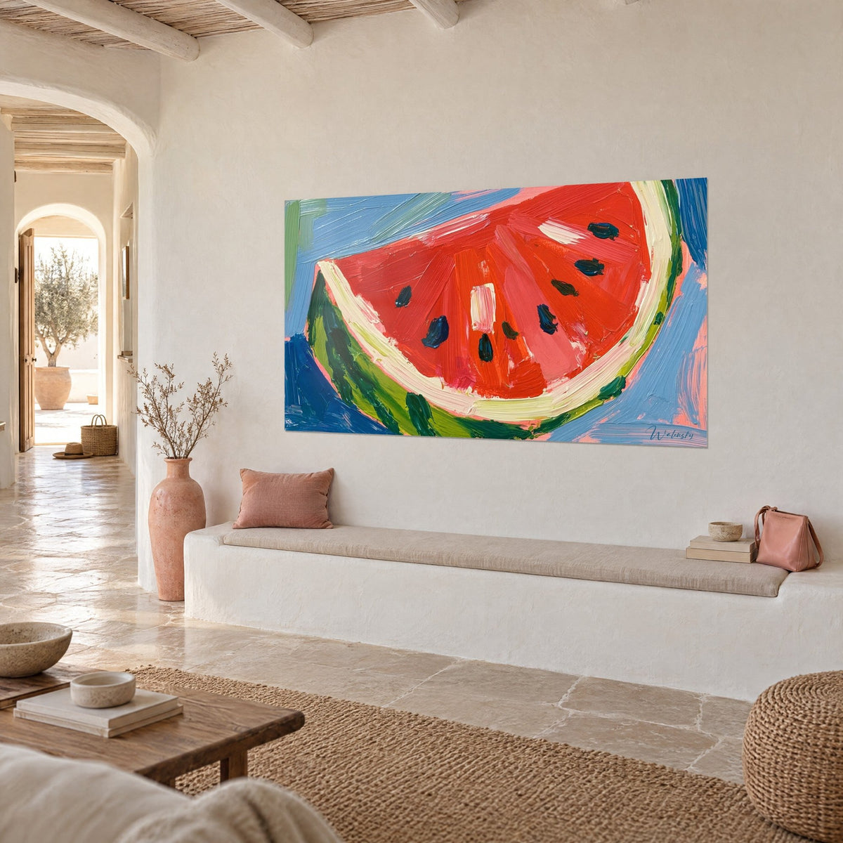 Wall art of a vermilion red fruit with a green and cream rind, pastel blue background, hung in a whitewashed Mediterranean home