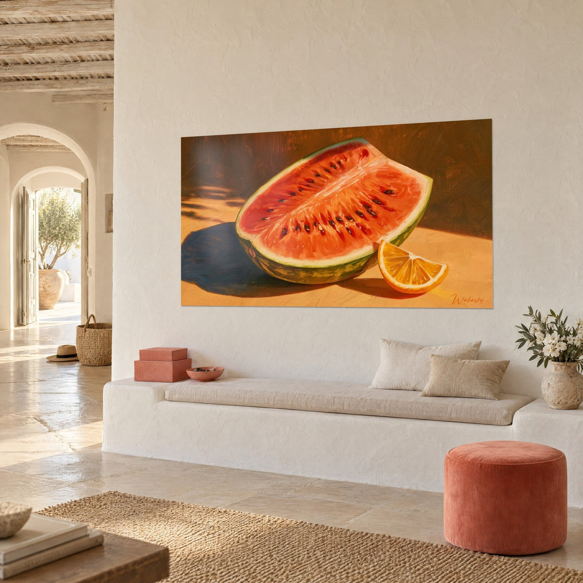 Tableau demi-melon d'eau corail aux pépins noirs sur fond brun ocre, accroché près d'une banquette blanche et d'un pouf terracotta