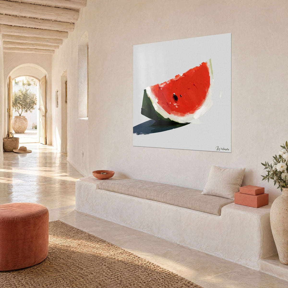 Wall art slice of watermelon in scarlet red with an ivory rind and black seed, hung at a three-quarter angle near a light bench