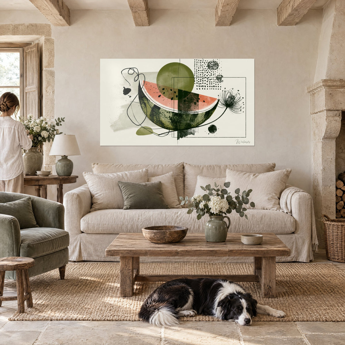 Tableau tranche de pastèque corail au cœur olive, une femme et un collie devant, accroché au-dessus d'un canapé dans un salon lumineux