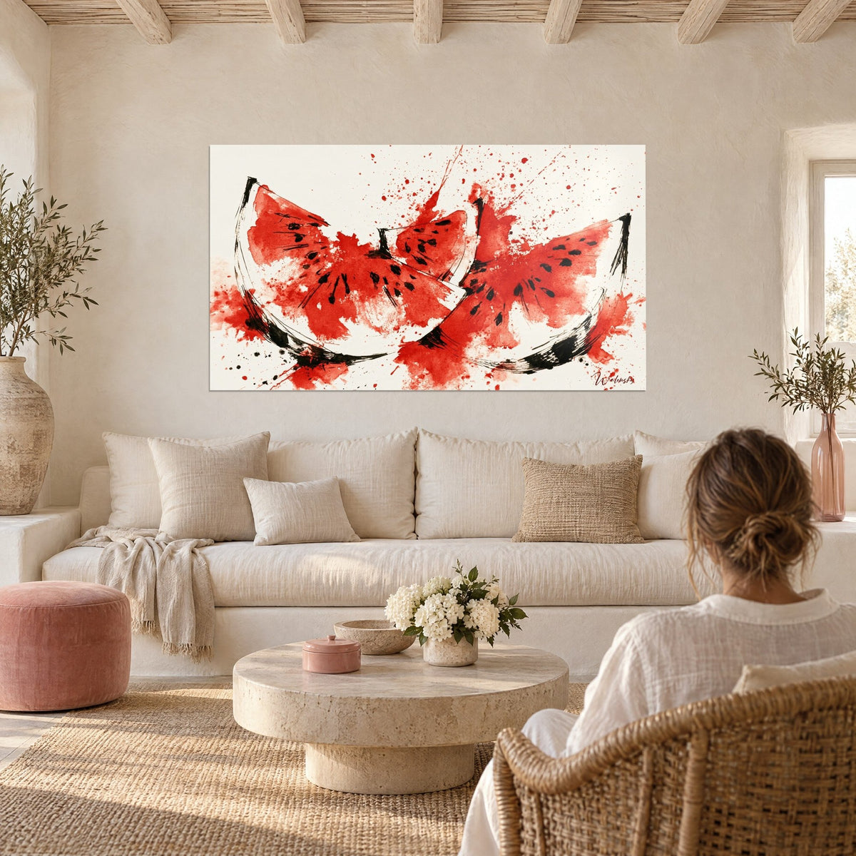 Wall art red and black watermelon slices, splashes on a cream background, hanging above a sofa in a bright living room