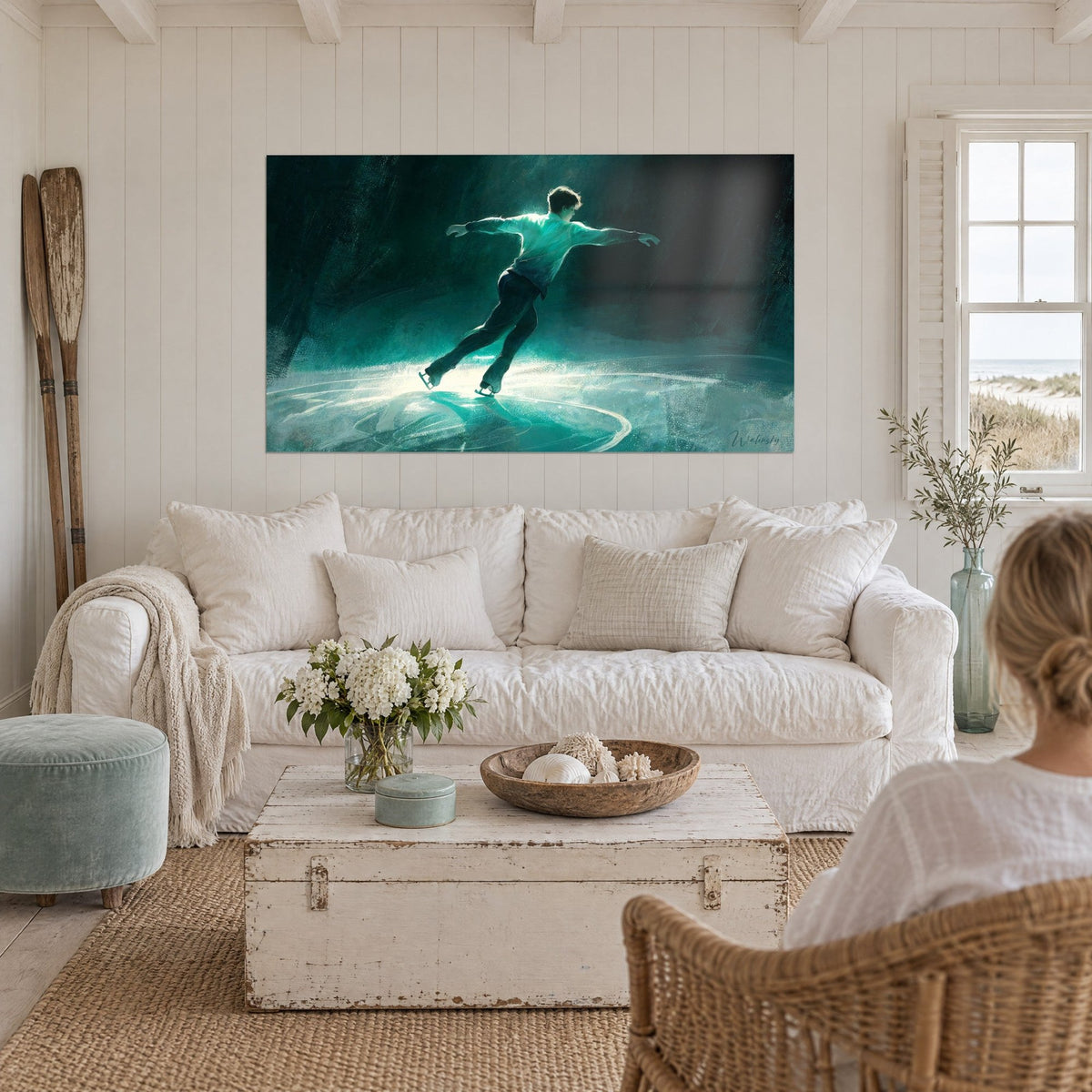Wall art of a figure skater with arms outstretched on turquoise and black ice, backlit silhouette above a sofa in a bright living room