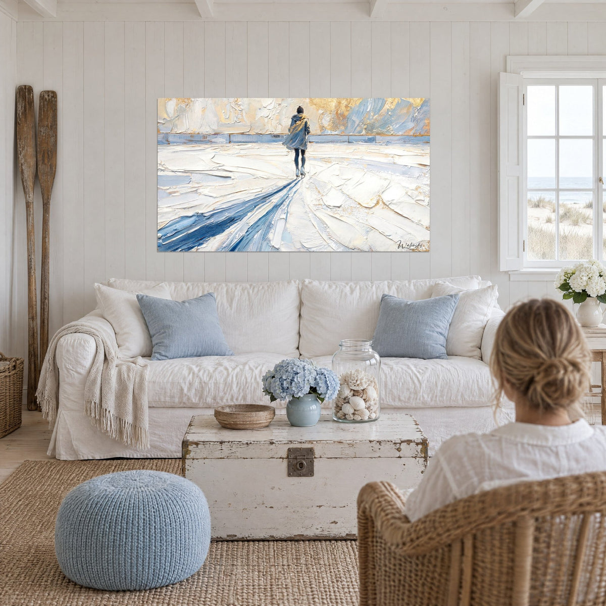 Wall art of a skater seen from behind gliding on white ice, blue and gold shadows, above a sofa in a bright living room