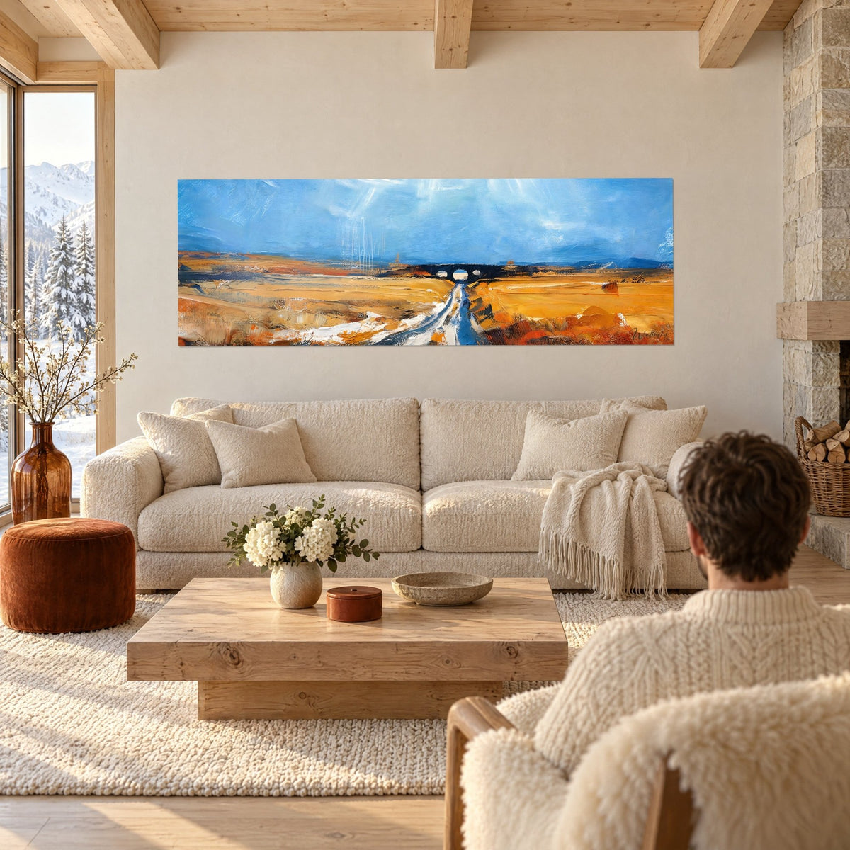 Tableau chemin de campagne bleu et ocre menant à un pont, au-dessus d'un canapé dans un salon lumineux