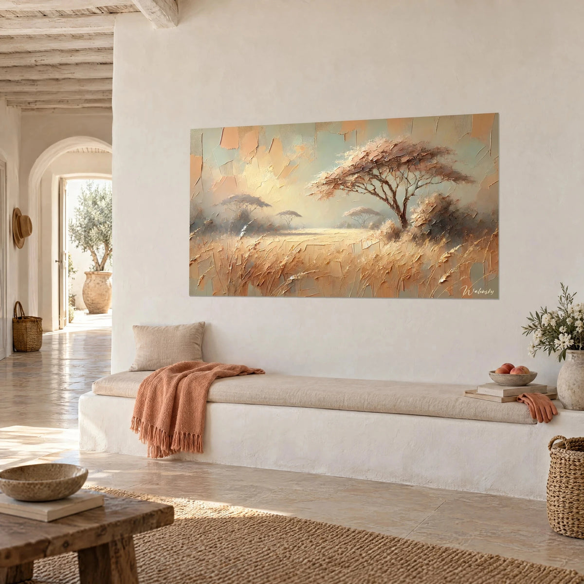 Cuadro de árbol paraguas de ramas rosadas, llanura beige y cielo verde salvia, colgado junto a un banco blanco de una casa mediterránea