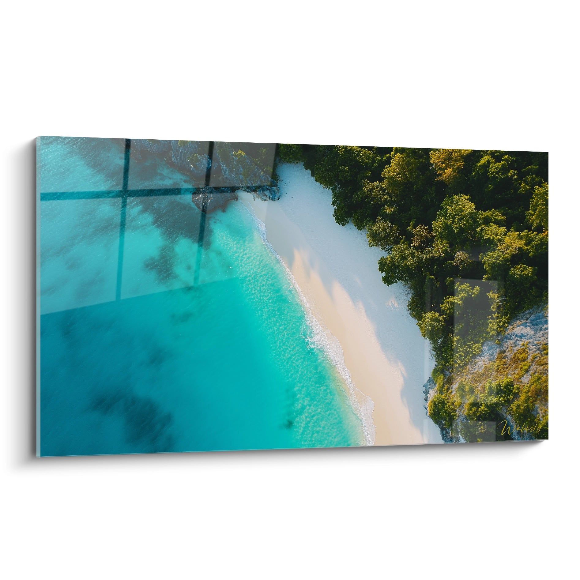 Un tableau plage représentant une vue aérienne d'un lagon turquoise avec une forêt tropicale verte sur le côté droit et des ombres d'arbres projetées sur l'eau cristalline.
