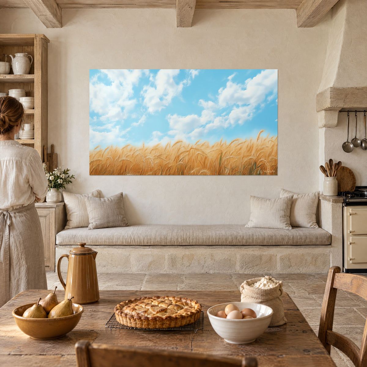 Cuadro de gavillas doradas bajo nubes esponjosas azul claro, sobre una pared enlucida de una cocina de piedra con banqueta beige