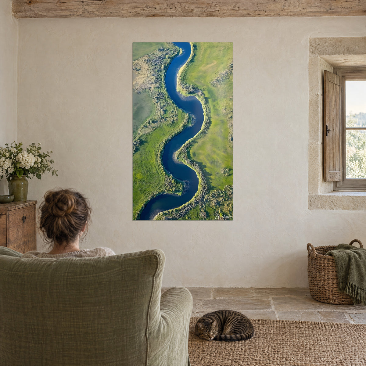 Quadro linea d'acqua blu reale che si snoda tra prati smeraldo, di fronte a una poltrona verde salvia, gatto tigrato addormentato sul tappeto