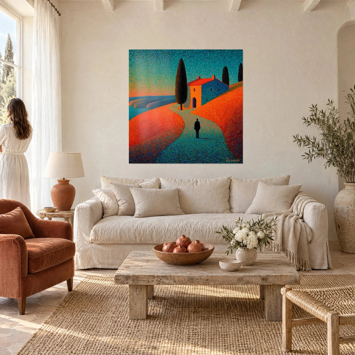 Tableau mas provençal aux murs bleu cobalt, toit rouge vif et cyprès noir, collines orange, femme de dos, au-dessus d'un canapé dans un salon lumineux