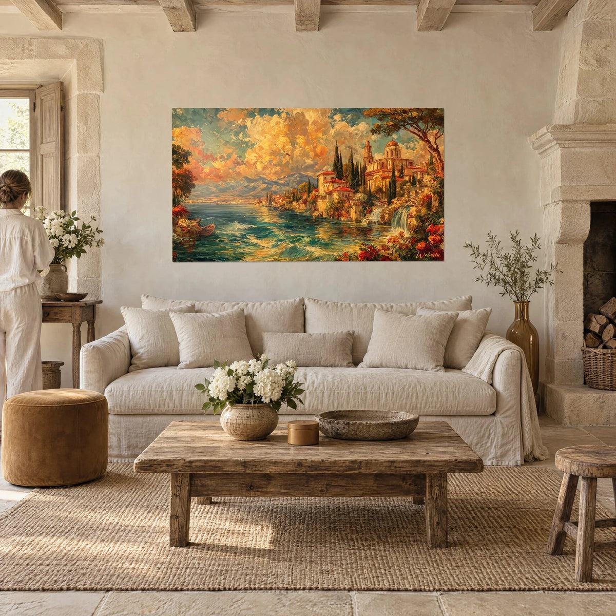 Gemälde toskanisches Dorf mit roten Ziegeldächern unter orangefarbenen Wolken, zwei Personen von hinten, über einem Sofa in einem lichtdurchfluteten Wohnzimmer