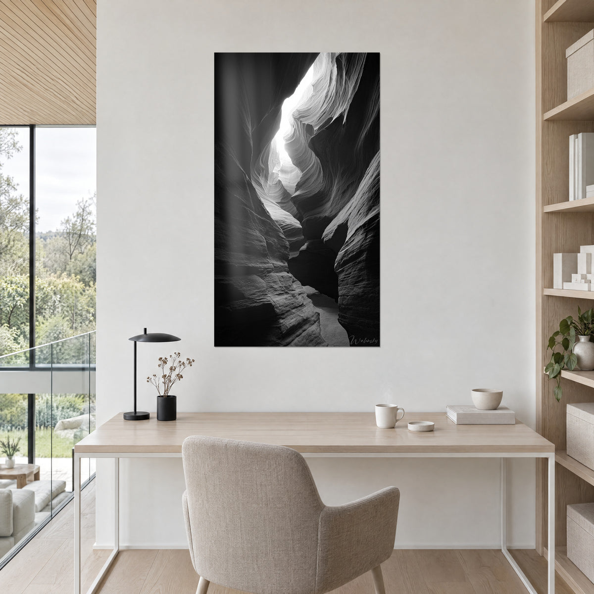 Schilderij steenspleet met minerale golven, witte gloed bovenaan en zwarte schaduwen, crèmekleurige muur boven een bureau van licht hout