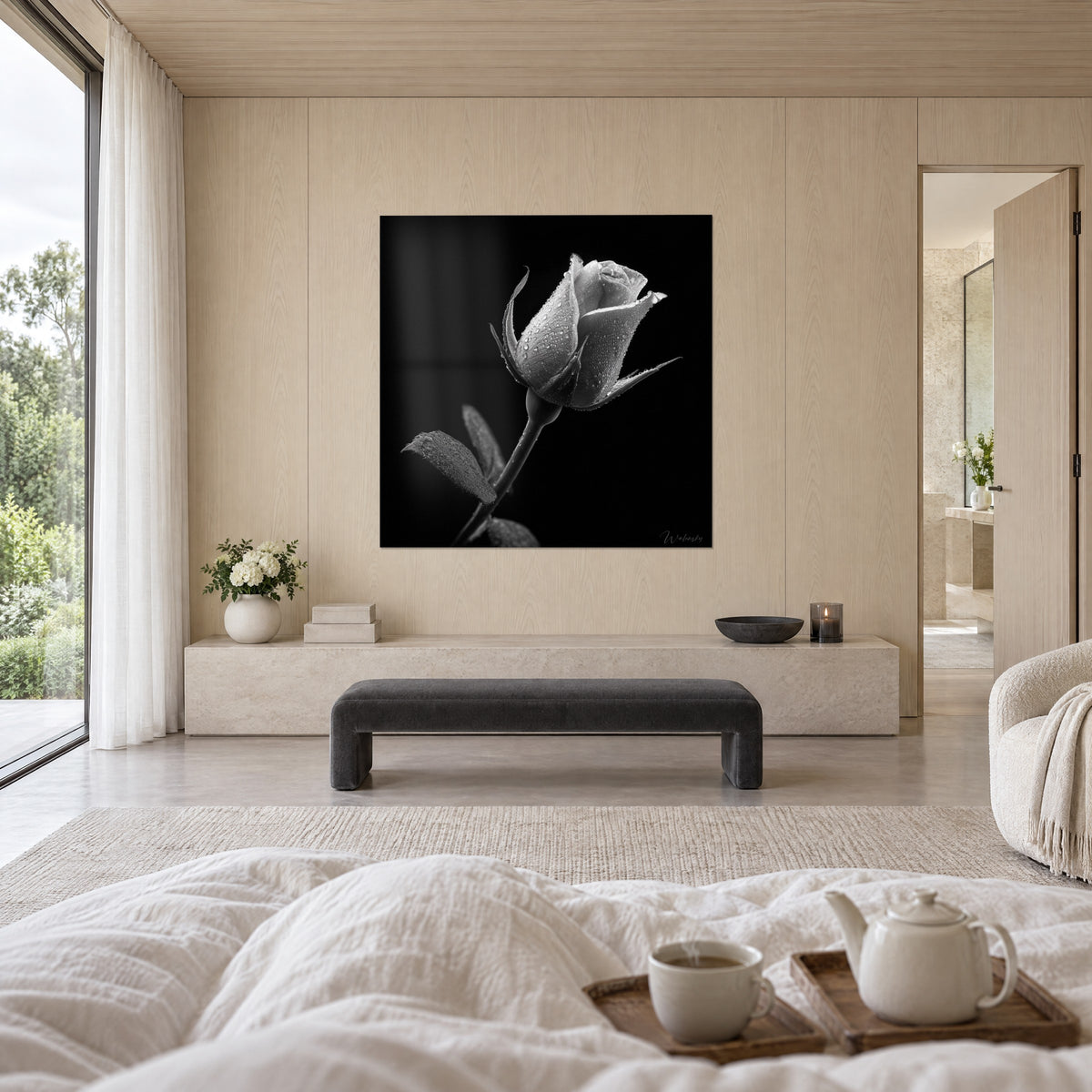 Tableau fleur de rose encore close, pétales gris clair constellés de gouttes sur noir profond, au-dessus d'un lit dans une chambre claire
