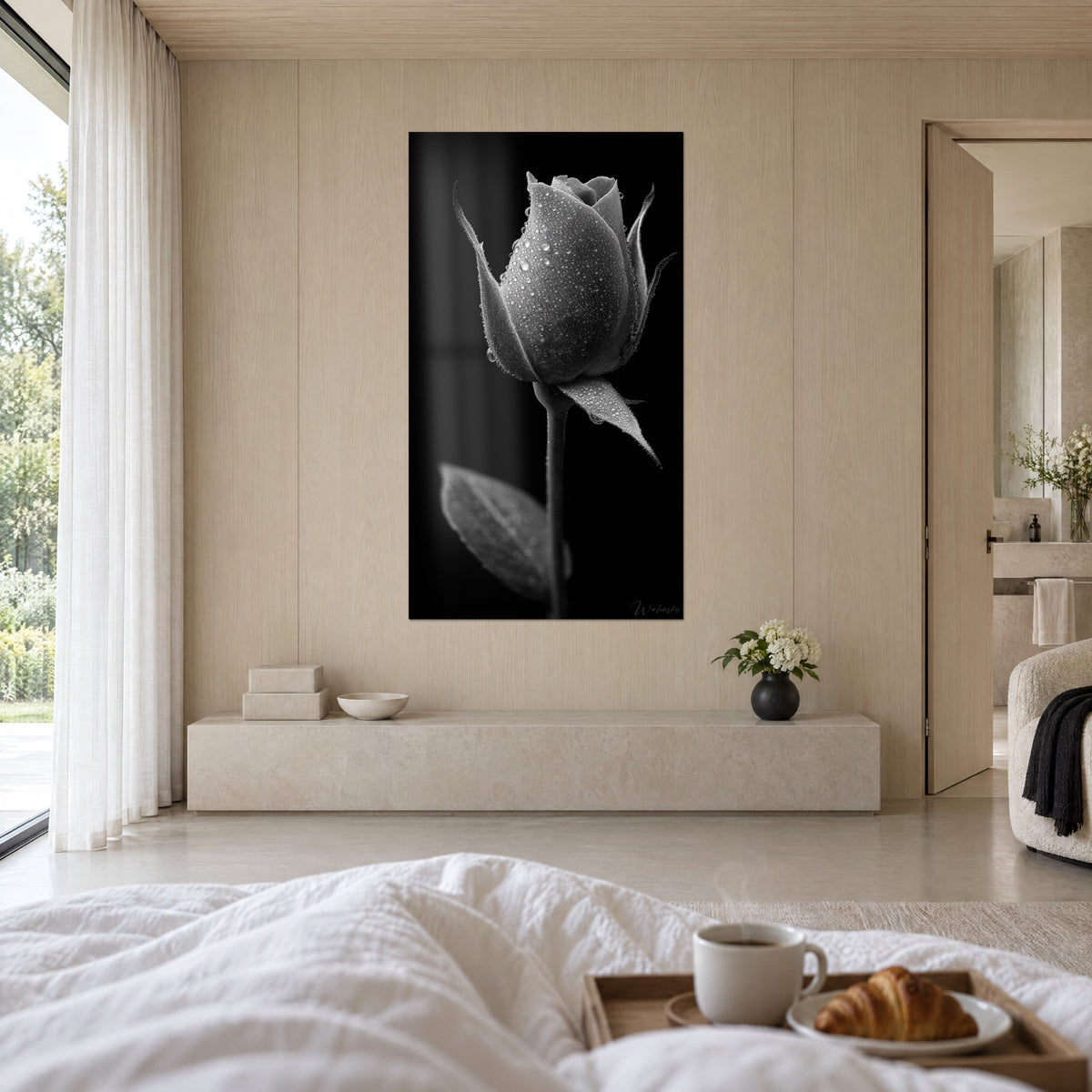 Cuadro capullo floral escarchado de perlas de agua, gama de gris claro y negro aterciopelado, colgado sobre una cama en un dormitorio luminoso