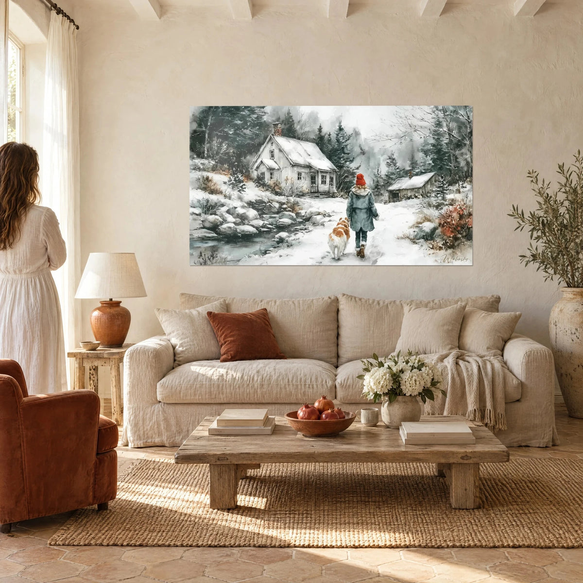 Wall art snowy cottage with grey shutters, walker in a red bobble hat and ginger dog, above a sofa in a bright living room