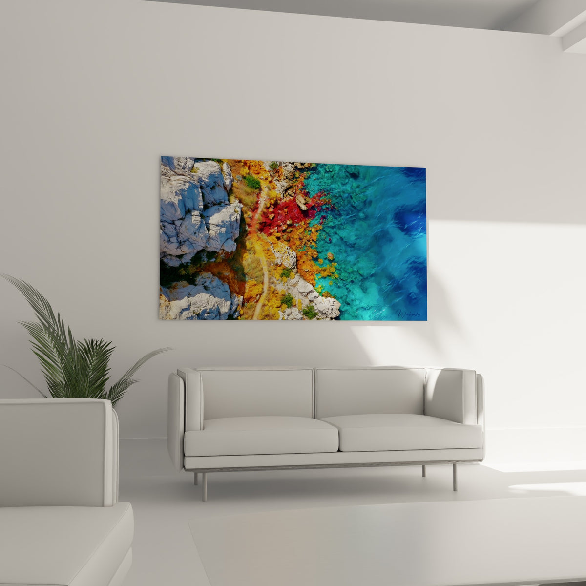 Falaises blanches et eau bleu marine d'une calanque suspendues au-dessus d'un canapé dans un salon lumineux