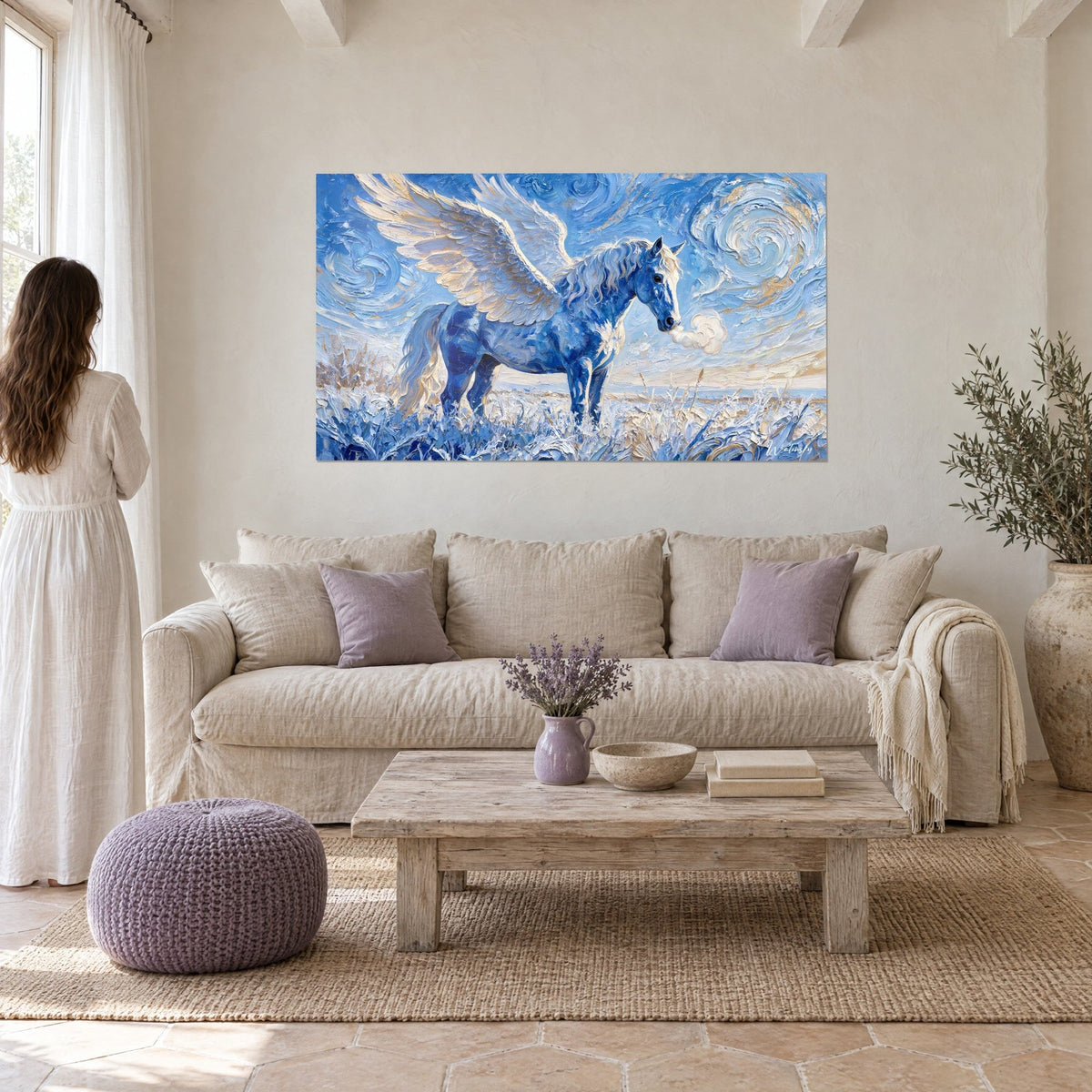 Wall art winged horse in cobalt blue with ivory and gold feathers, swirling sky, above a sofa in a bright living room