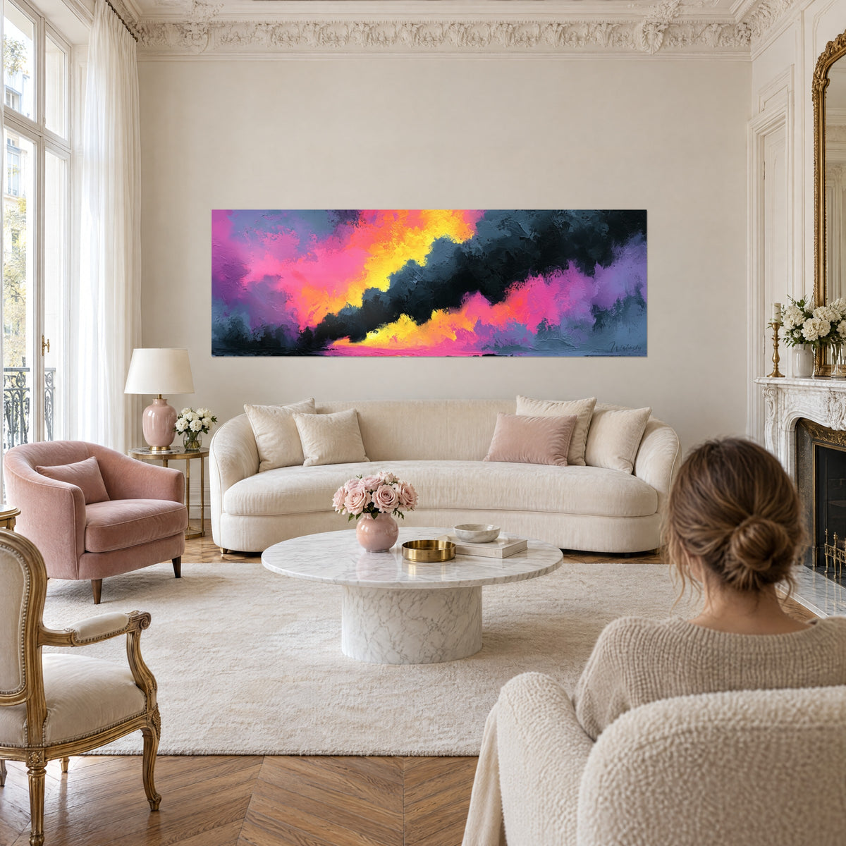 Cuadro de nubes incandescentes en amarillo limón y rosa fucsia sobre fondo antracita, colgado encima de un sofá en un salón luminoso