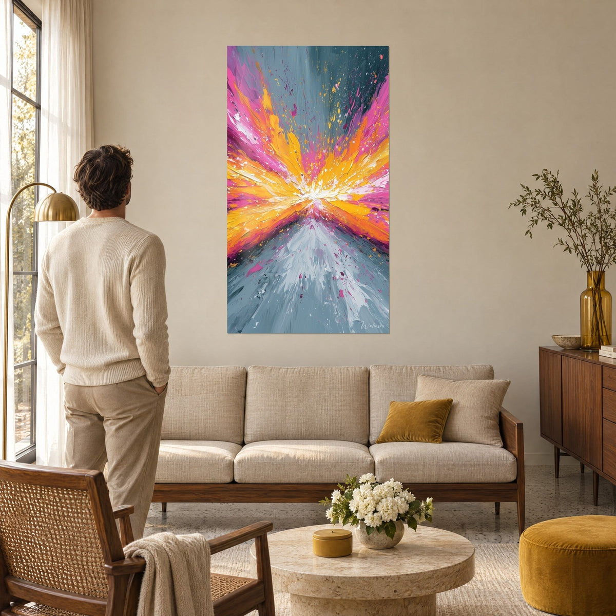 Cuadro explosión de pintura rosa y naranja que brota de un punto blanco, fondo gris azulado, encima de un sofá en un salón luminoso
