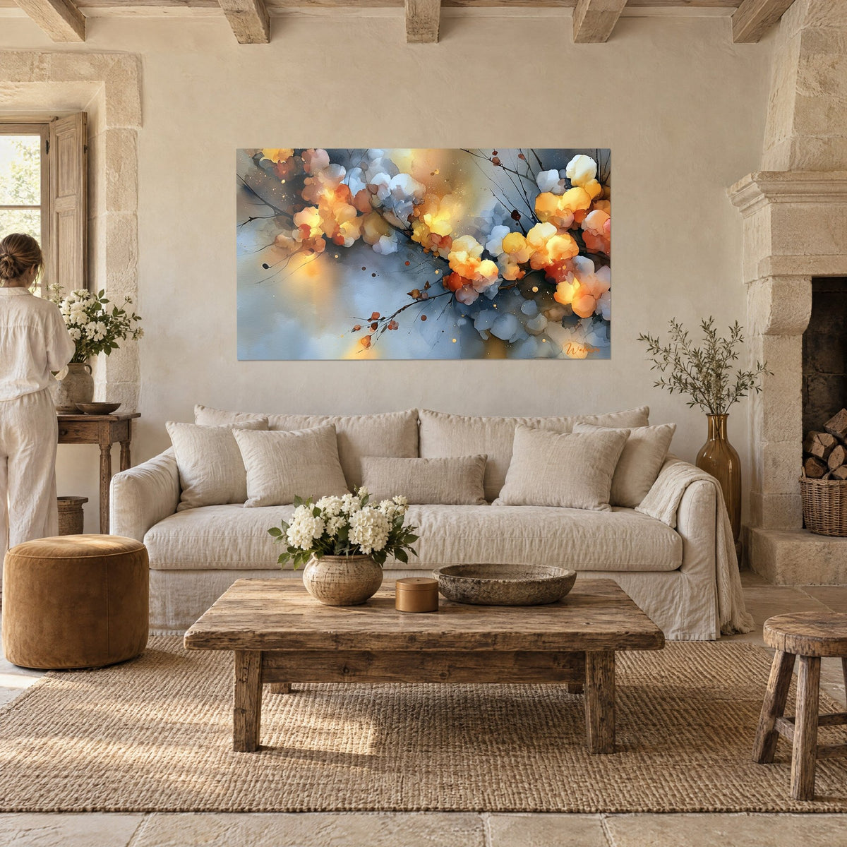 Gemälde mit verzweigtem Blütenzweig in Gold, ockerfarbenen und graublau schimmernden Blütenblättern, betrachtet von einer Frau von hinten, über einem Sofa in einem hellen Wohnzimmer