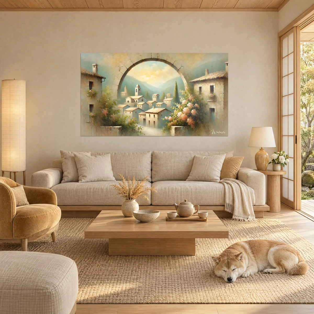 Tableau village de pierre vu par une arche, bleu turquoise et ocre doré, fleurs roses, Shiba au-dessus d'un canapé dans un salon lumineux