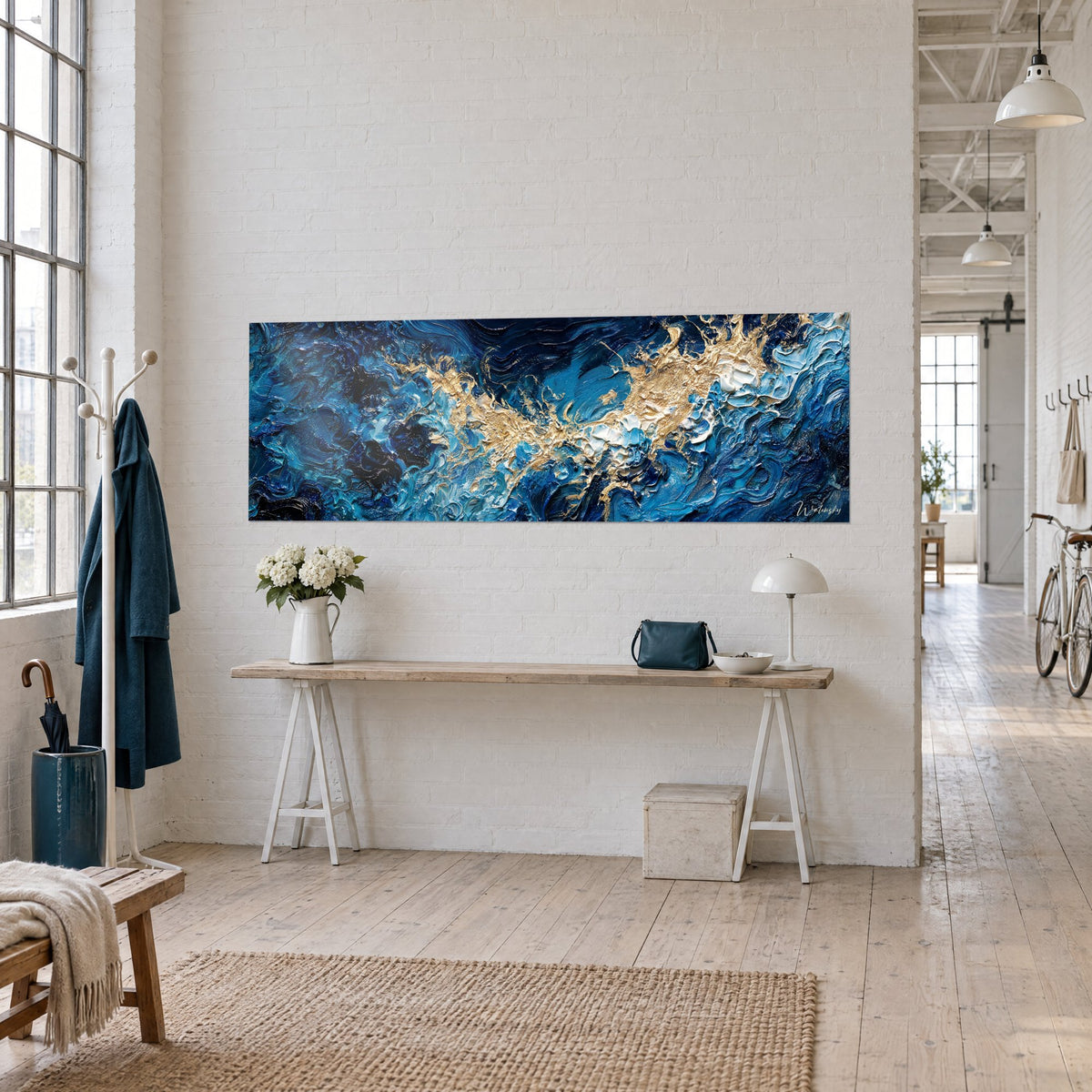 Tableau éclaircie dorée sur flots indigo, empâtements en relief, accroché au mur d'un loft près d'une console blanche et d'un bouquet