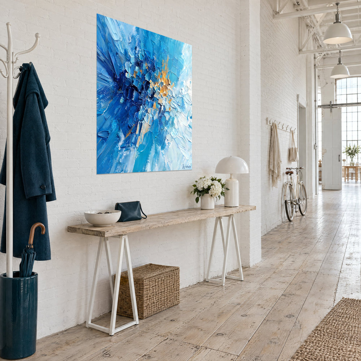 Tableau explosion de bleu roi et de blanc glacé au couteau, touches orangées, vue en biais près d'une console en bois
