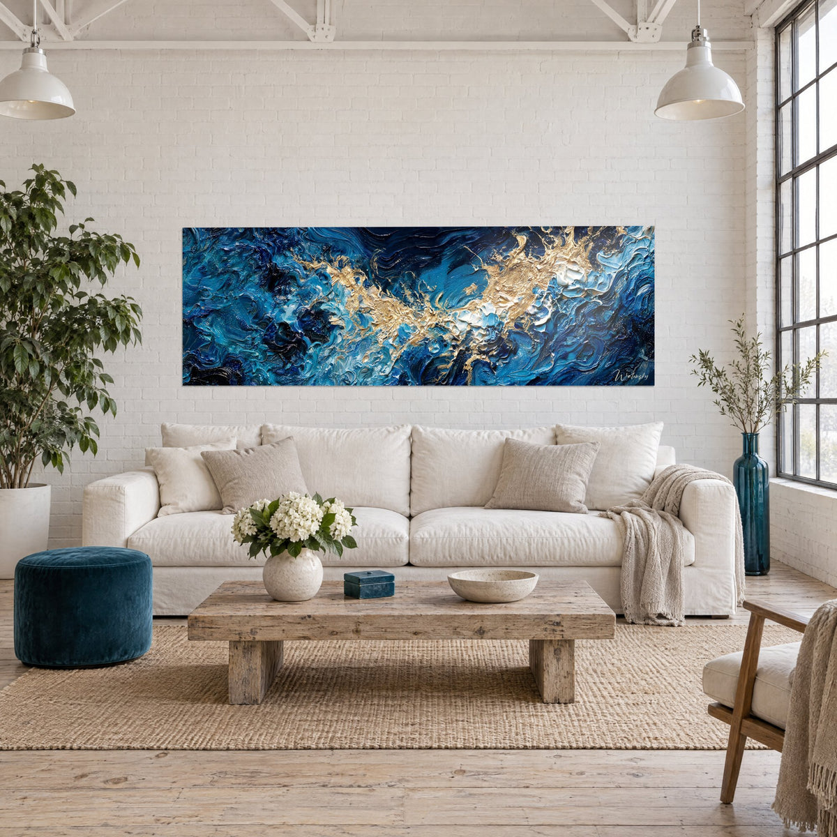 Tableau vagues houleuses bleu marine striées d'or et d'écume blanche, pâte épaisse, au-dessus d'un canapé dans un salon lumineux