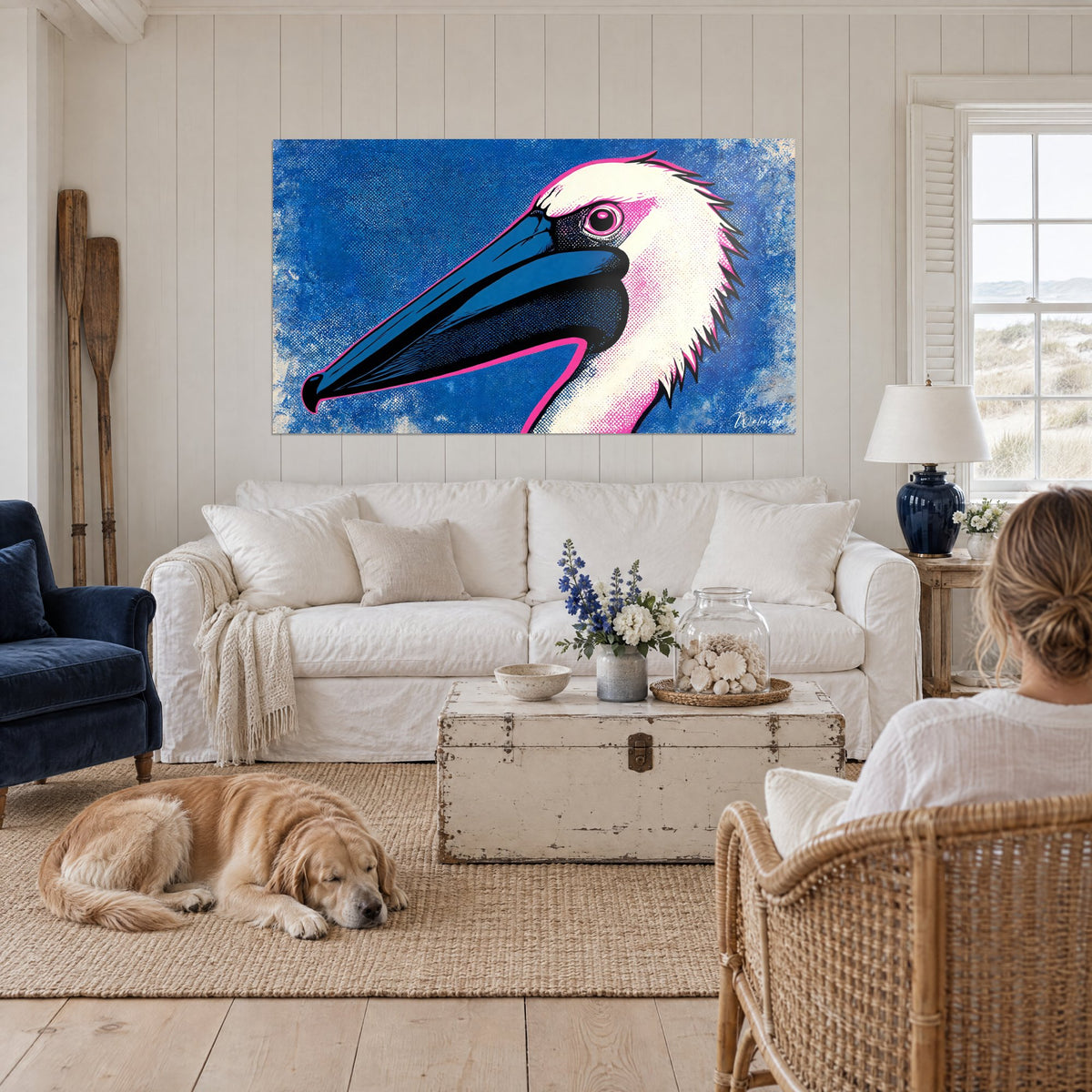 Tableau pélican à tête blanche et long bec bleu nuit sur fond cobalt, au-dessus d'un canapé dans un salon lumineux