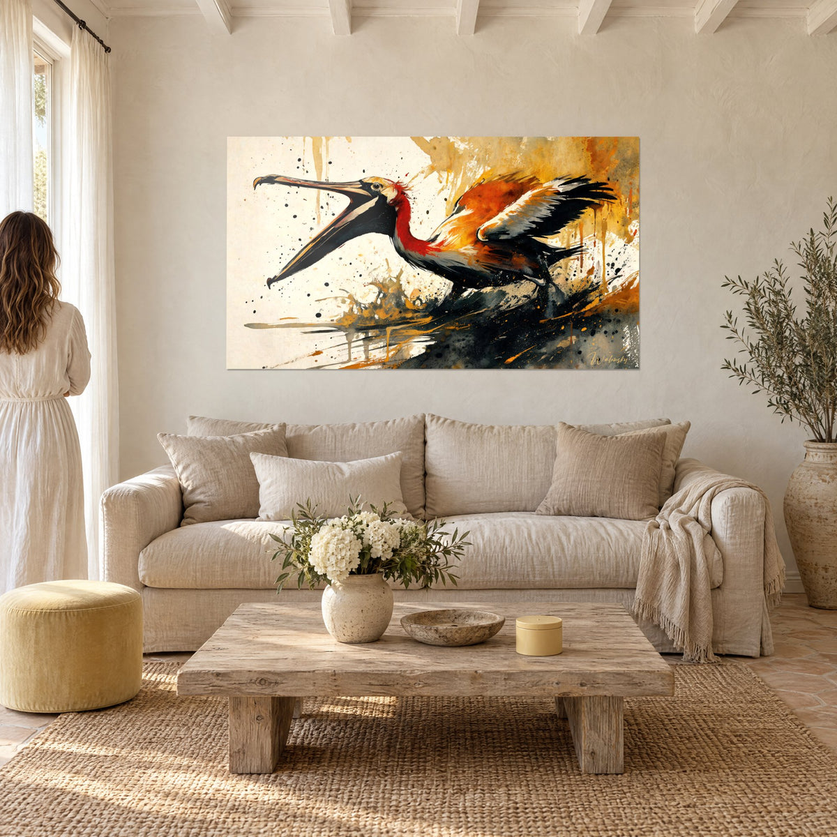 Tableau pélican au long bec ouvert, plumes orange et noires, fond crème éclaboussé, au-dessus d'un canapé dans un salon lumineux
