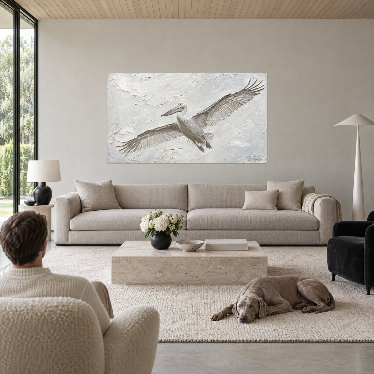 Tableau pélican blanc en plein vol, ailes grises déployées sur fond crème empâté, au-dessus d'un canapé dans un salon lumineux