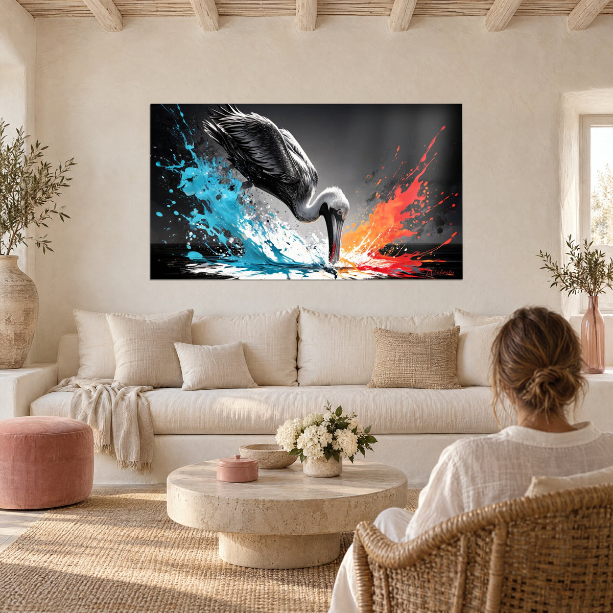 Tableau pélican plongeant le bec dans l'eau, éclaboussures turquoise et rouge sur fond noir, au-dessus d'un canapé dans un salon lumineux