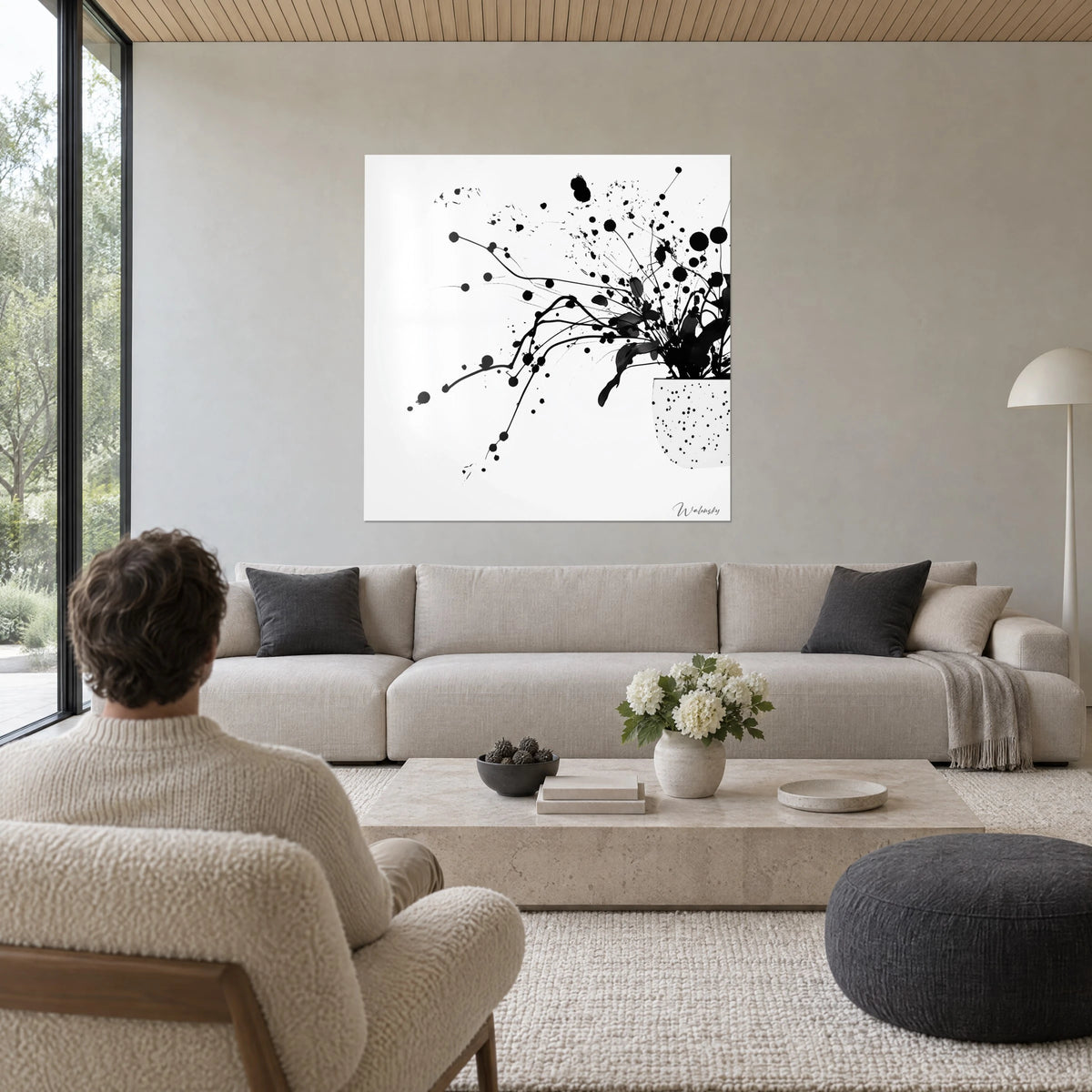 Schilderij zwart inktboeket in een bundel, spatten op puur witte achtergrond, boven een bank in een lichte woonkamer