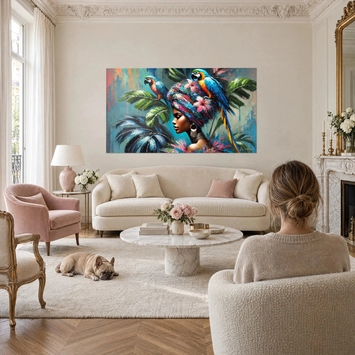 Schilderij blauw-gele ara neergestreken op een roze bloemenbanddoek, koppel van achteren boven een bank in een lichte woonkamer