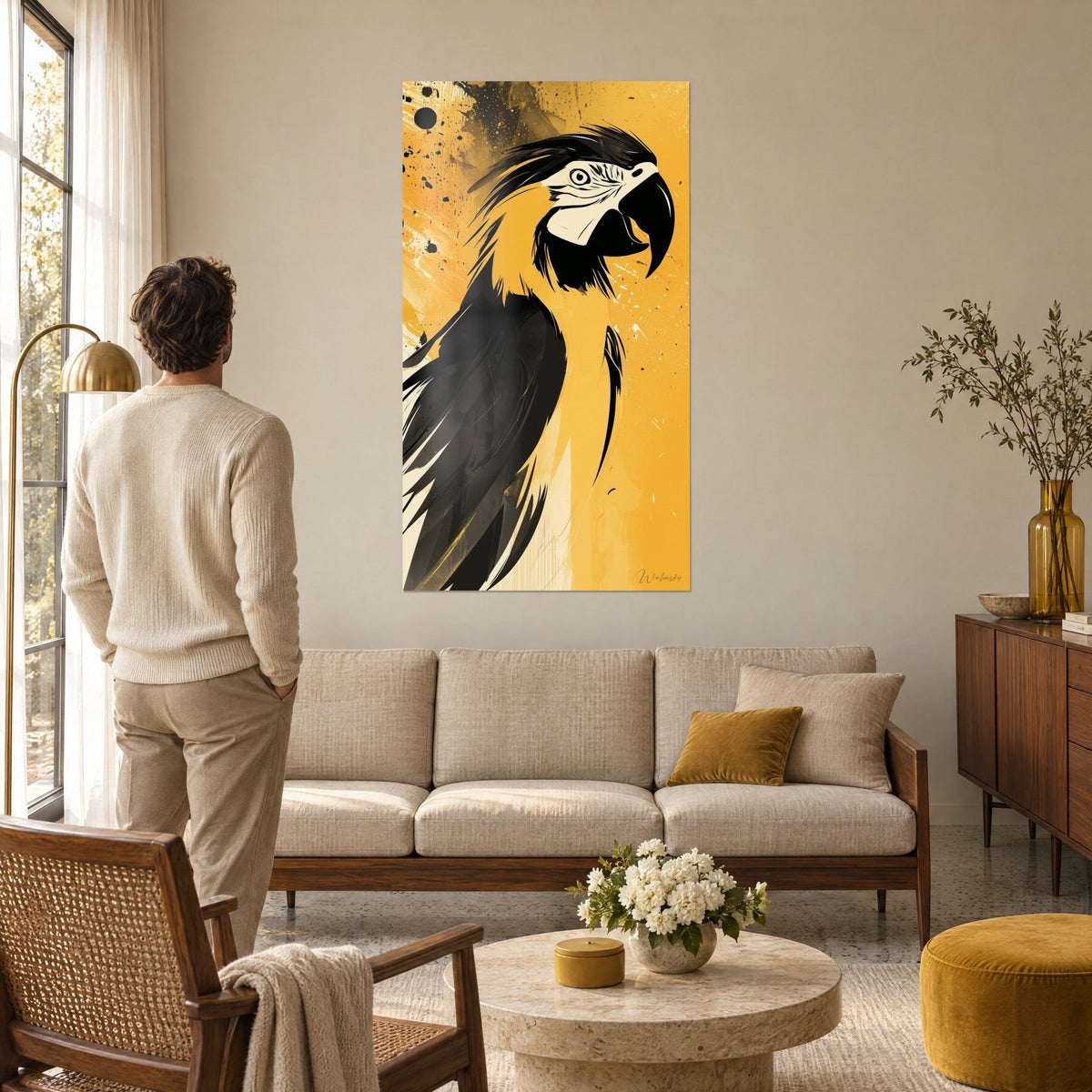 Wall art parrot macaw with curved black beak, mustard yellow and ink black plumage, dark splatters, man seen from behind above a sofa in a bright living room