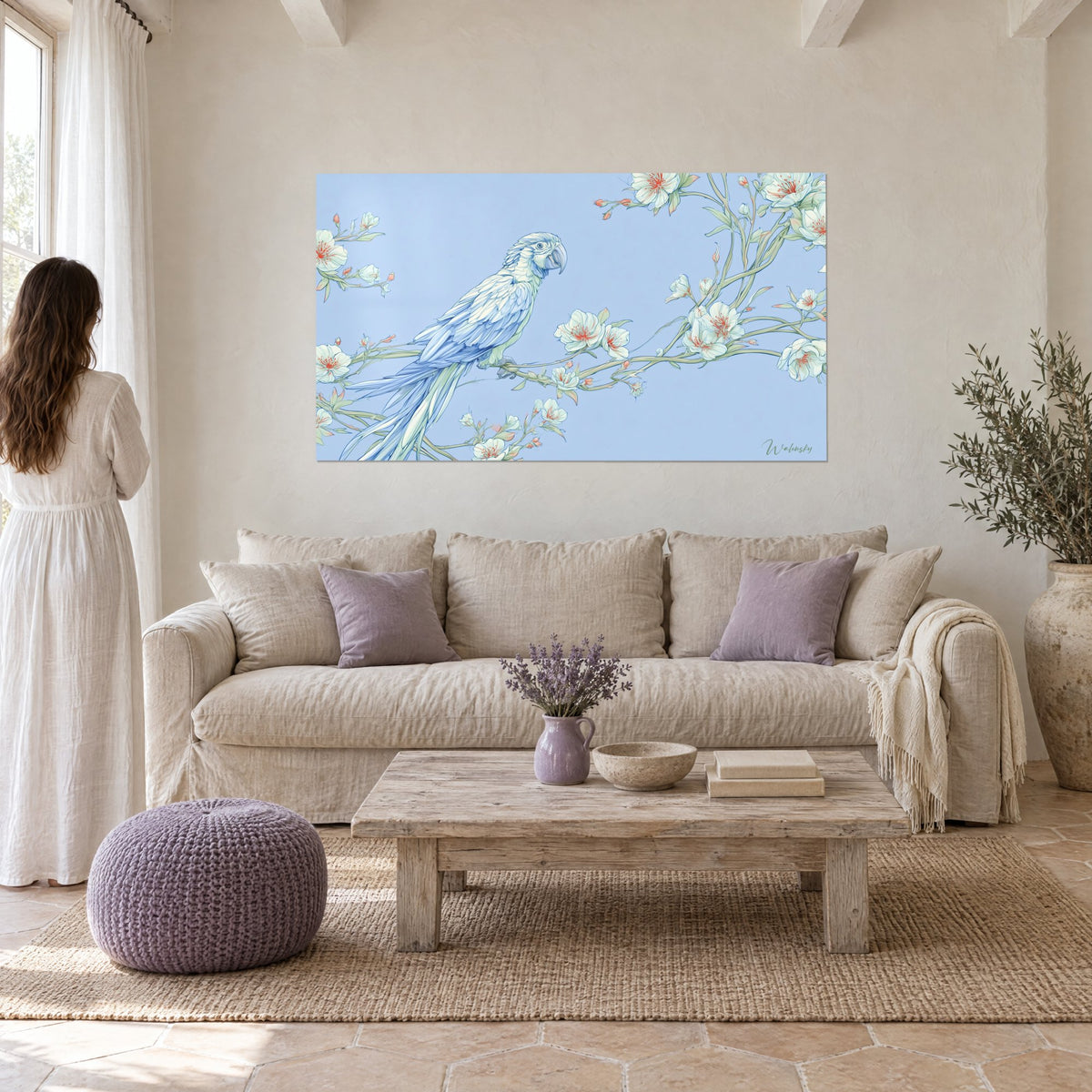 Wall art of a pastel blue parrot perched on an almond branch with white and red blossoms, above a sofa in a bright living room