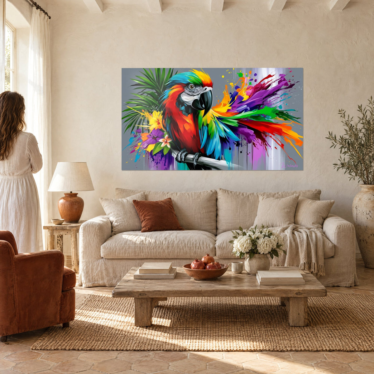 Schilderij scharlaken ara met turquoise en paarse veren, grijze achtergrond, twee personen van achteren, boven een bank in een lichte woonkamer